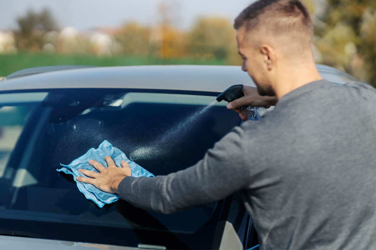 Vetri auto perfettamente puliti dopo lavaggio con spray antigoccia e panno in microfibra