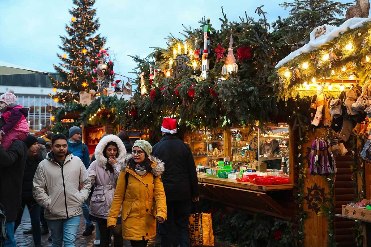 Città illuminata per Natale con mercatini e alberi decorati