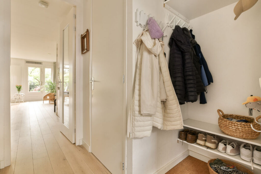 Ingresso ordinato con tappeto, contenitore e svuotatasche per un impatto accogliente