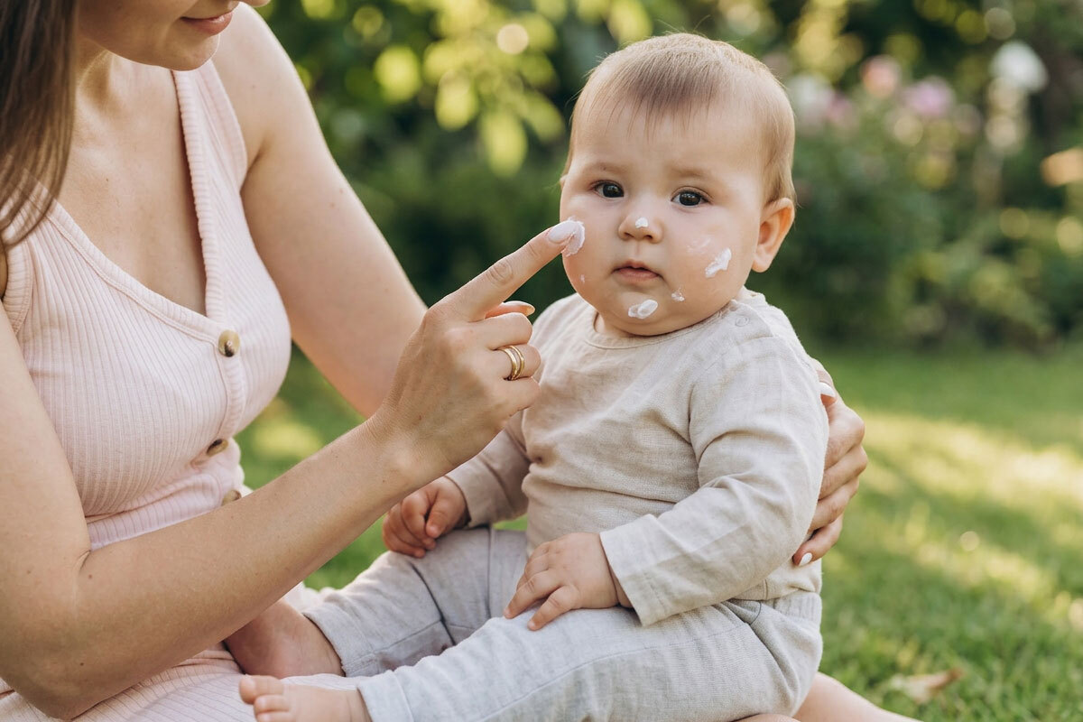 Applicazione crema solare su bambino durante giornata primaverile