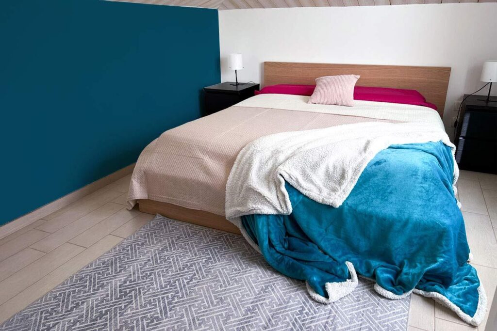 Camera da letto primaverile con plaid e cuscini dai colori chiari