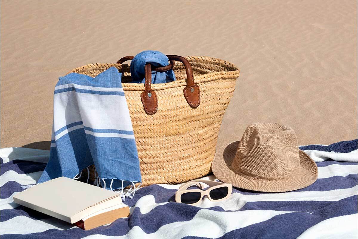 Accessori base per il mare con telo, crema solare e occhiali