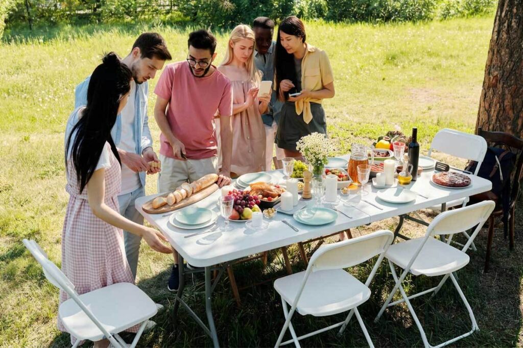 Picnic primaverile in parco con tavoli e sedie pieghevoli